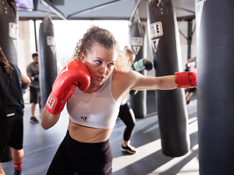 female boxing and punching weighted bag